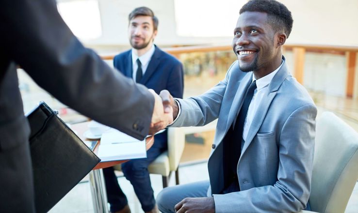 Two men in suits shaking hands