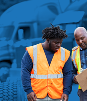 two men wearing hi-vis vests discussing their journeyman jobs